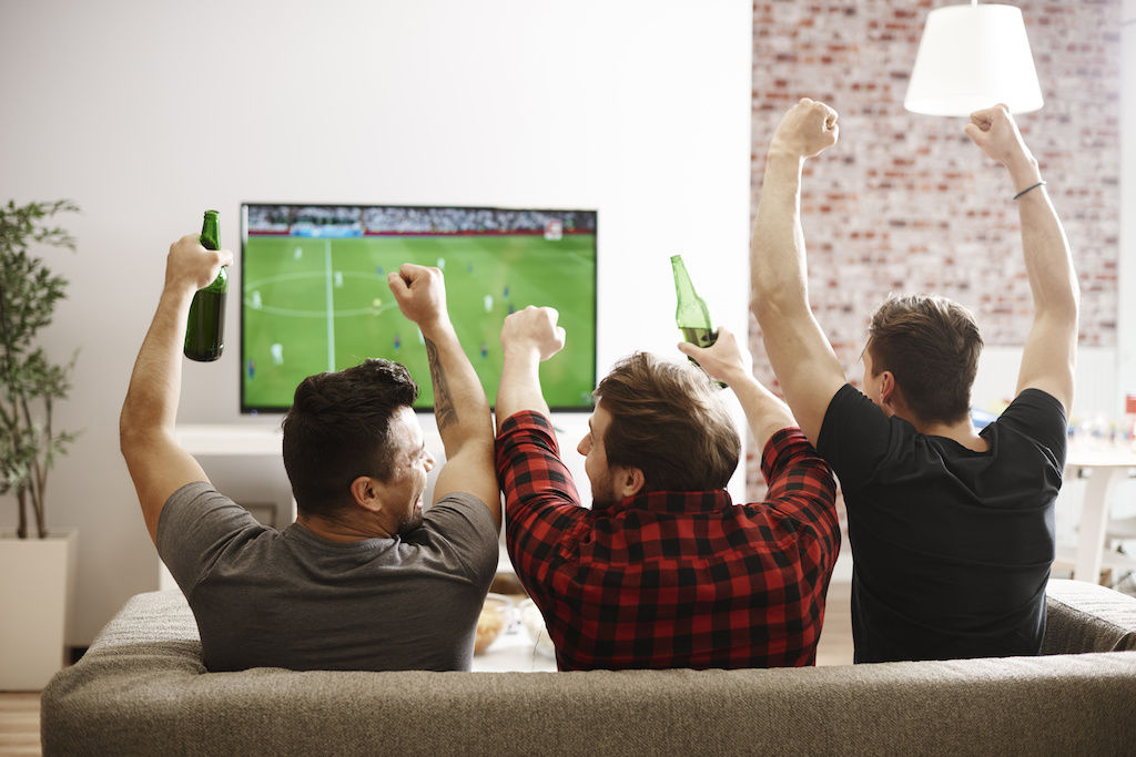 3 guys watching soccer match on TV